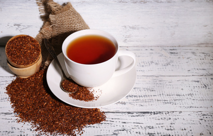 Cup of tasty rooibos tea, on old white wooden table